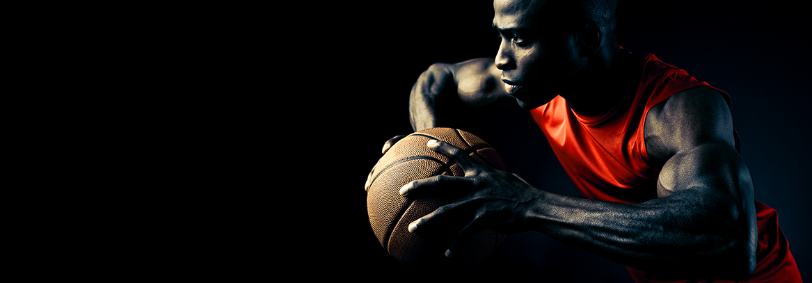 Strong basketball player holding the ball